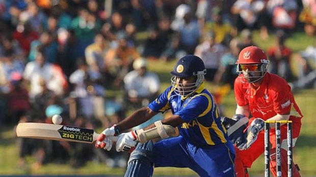 Mahela Jayawardene plays an ungainly reverse sweep as Canada's wicketkeeper Ashish Bagai looks on.