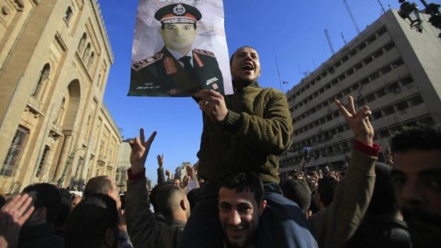 Outcry: A man holds a poster of army chief General Abdel Fatah al-Sisi during an anti-Muslim Brotherhood protest after the explosions.