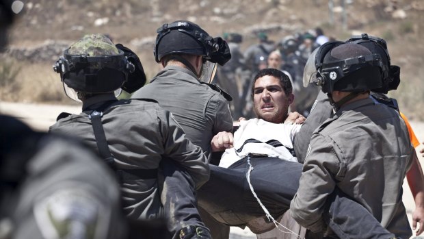 Israeli paramilitary police detain a Jewish settler protesting the demolition of two partially-built dwellings in the West Bank Jewish settlement of Beit El near Ramallah July 29, 2015. Israel gave final approval on Wednesday for plans to build 300 new homes in the Jewish settlement in the occupied West Bank, announcing the move as it carried out a court demolition order against the two vacant apartment blocs at the site. Dozens of Jewish settlers have gathered over the past several days at Beit El settlement to protest against the demolition. REUTERS/Emil Salman ISRAEL OUT. NO COMMERCIAL OR EDITORIAL SALES IN ISRAEL