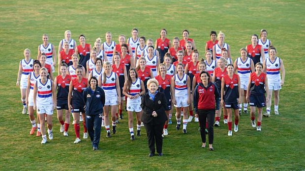 Western Bulldogs director Susan Alberti with the two women's teams that will play before the Bulldogs-Melbourne game at the MCG on Saturday.