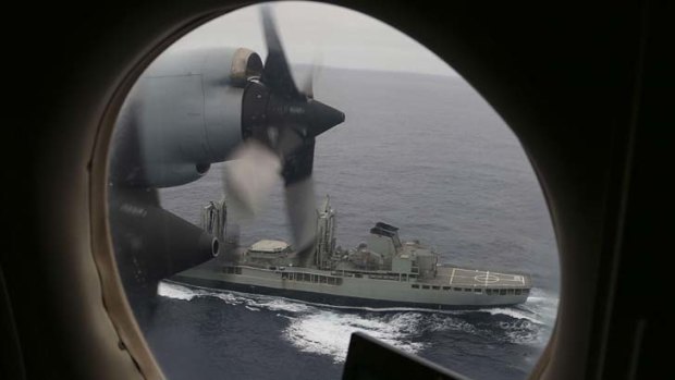 A Royal Australian Air Force AP-3C Orion flies past  HMAS Success as they search for missing Malaysia Airlines flight MH370  in the southern Indian Ocean on March 22, 2014.