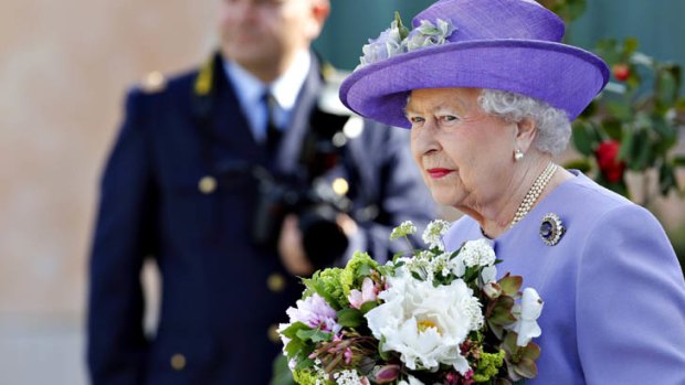 Britain's Queen Elizabeth II holds flowers as she leaves the Ciampino Airport in Rome April 3, 2014.