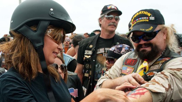 Sarah Palin  looks at a rider's tattoo during the Rolling Thunder  Memorial Day weekend parade.
