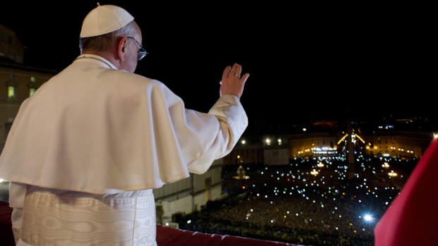 Pope Francis waves the crowd from the central balcony of St. Peter's Basilica at the Vatican.