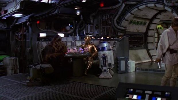 Chewbacca (Peter Mayhew) playing R2-D2 (Kenny Baker) in a holographic chess game, while C3-PO (Anthony Daniels) looks on, in a scene from the 1977 film Star Wars.