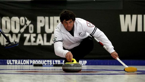 Swept up ... Sean Becker of New Zealand releases a stone during a curling match between New Zealand and Australia.