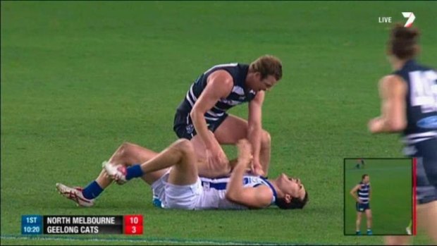 Geelong's Steve Johnson pushes his knee into the midriff of North Melbourne's Scott Thompson.