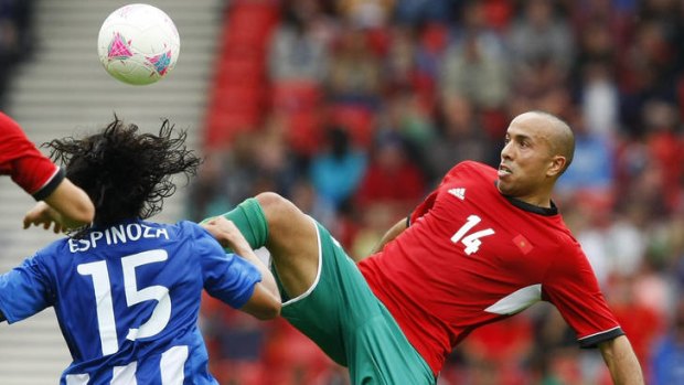 Morocco's Zouhair Feddal, right, challenges Honduras's Roger Espinoza for the ball.