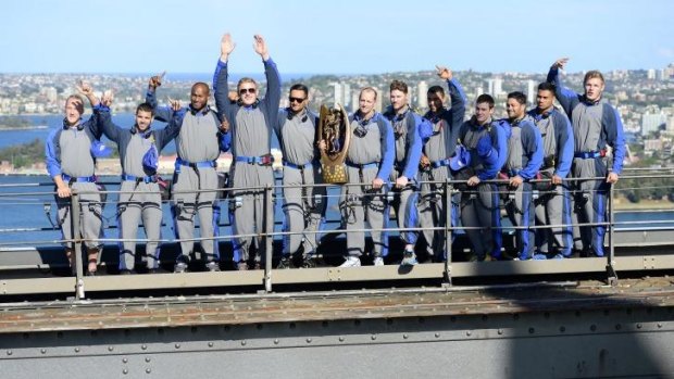 Long way to the top: Triumphant Rabbitohs pose with the trophy atop the Sydney Harbour Bridge.