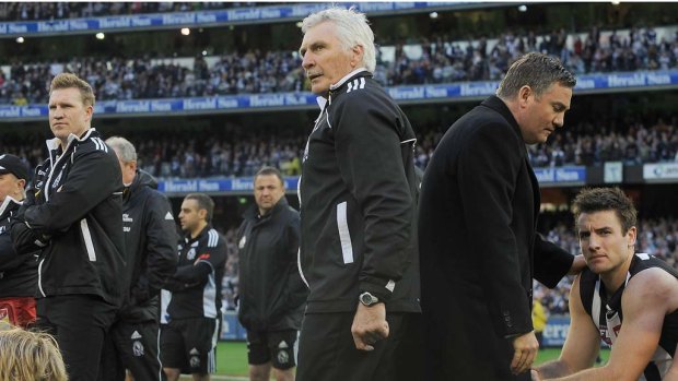 Fraught relationships. Collingwood coach Mick Malthouse centre, assistant coach Nathan Buckley, left and president Eddie McGuire right watch the presentation of the 2011 premiership cup to Geelong.