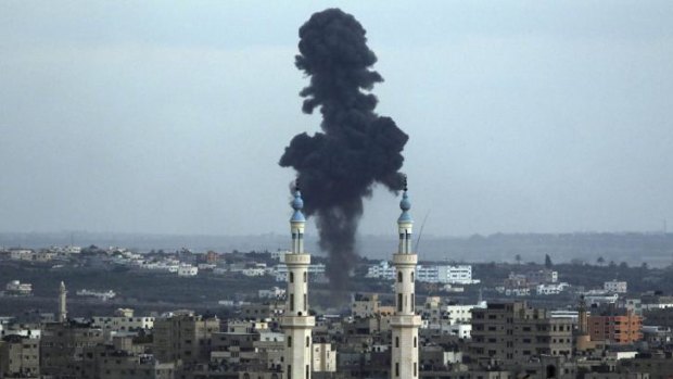 Smoke rises behind a mosque's minarets after an Israeli missile strike in Gaza City.