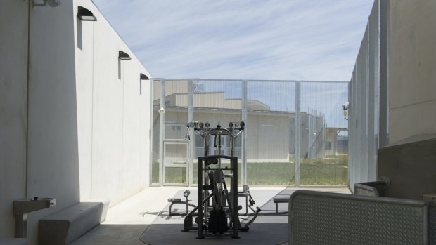 Gym equipment sits in the middle of a concrete courtyard.