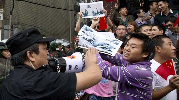 Textbook copy ... protesters in Chengdu last week hold a photograph depicting cruelty suffered by Chinese under Japanese occupation last century.
