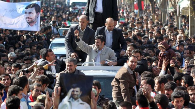 Iranian President Mahmoud Ahmadinejad, centre, waves to supporters while visiting the city of Shahrekord.