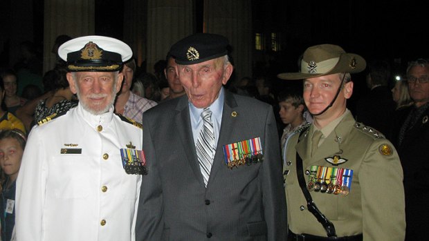 Alfred Eams, 90, with son Commander Robert Eams, left, and grandson Captain Drew Burkitt, right, at this morning's dawn service in Brisbane.