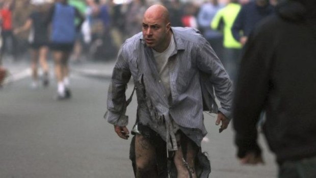 Boston Marathon bombing victim James Costello staggers away in his torn clothing from the finish area in Boston, on April 15, 2013.