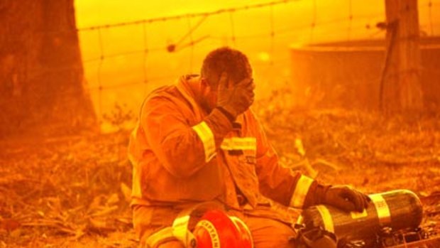 An unidentified firefighter is overcome by exhaustion at Bunyip State Park.
