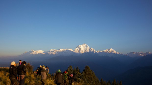 Tourists and trekkers enjoy view at dawn looking to Dhaulagiri from Poon Hill, Annapurna Region, Himalayas, Nepal, Asia.