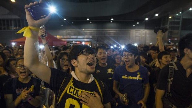 Student protesters shine lights from their phones as they chant pro-democracy slogans on the streets of Hong Kong.