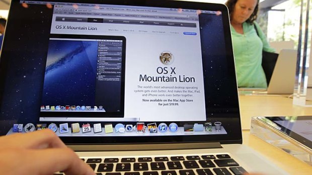 A customer looks at the new OS X Mountain Lion operating system at an Apple store in the US.