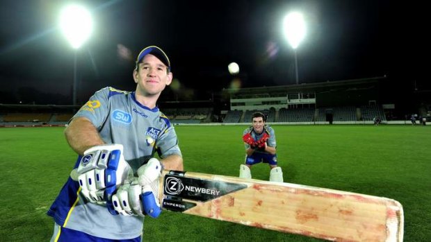 ACT Comets batsman Aaron Ayre and wicketkeeper Beau McClintock under the new lights at Manuka Oval.