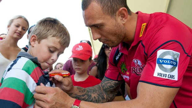 Quade Cooper signs the shirt of Austin Bishop,10, at The Reds Fan Day held at Ballymore Stadium, Feb. 9, 2013.
