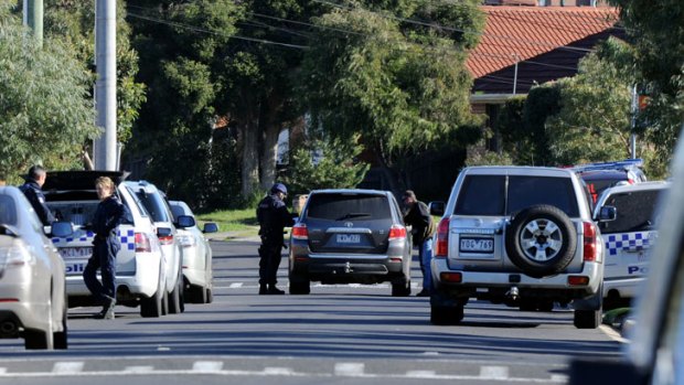 Police officers check a vehicle near the scene of the siege in Sterling Drive, East Keilor.