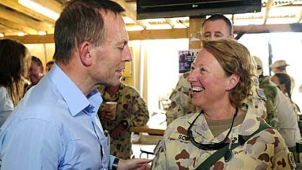 Tony Abbott is welcomed to the Australian recreation hut, Poppys, by Warrant Officer Class 1 Narelle Scott.