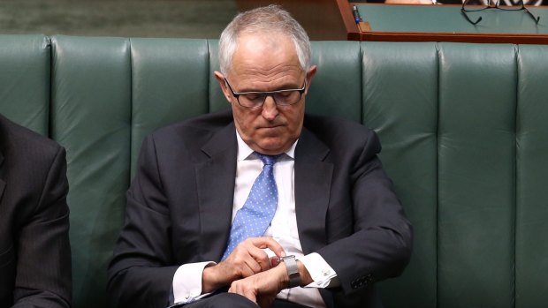 Communications minister Malcolm Turnbull adjusts his Apple watch during question time.