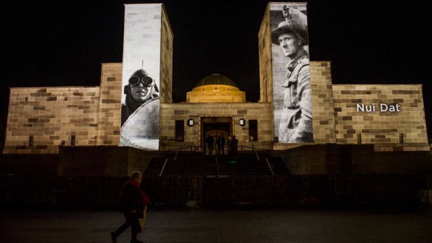 Pictures of service personnel and battles projected onto the war memorial on Anzac Day.