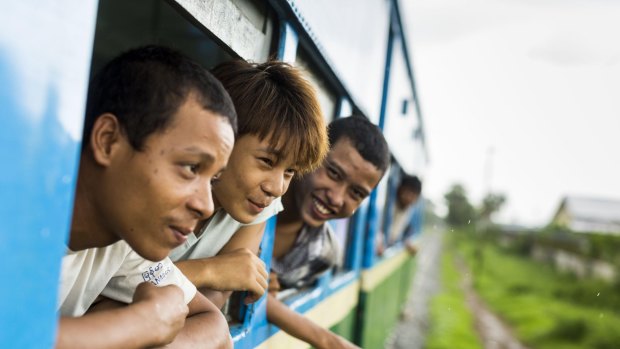 Passengers lean out of the windows of the Yangon Circular Train. 