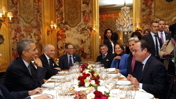 US President Barack Obama, left, sits with French President Francois Hollande, right,  as they have dinner at the Ambroisie restaurant in Paris, as part of the COP21.