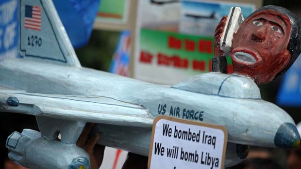 A protester holds a replica of a US jet fighter near the US embassy in Manila to denounce the decision to militarily intervene in Libya.