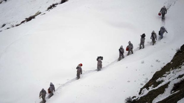 Pakistani soldiers carry supplies up the mountain near their outpost in Pakistan's Dir district.