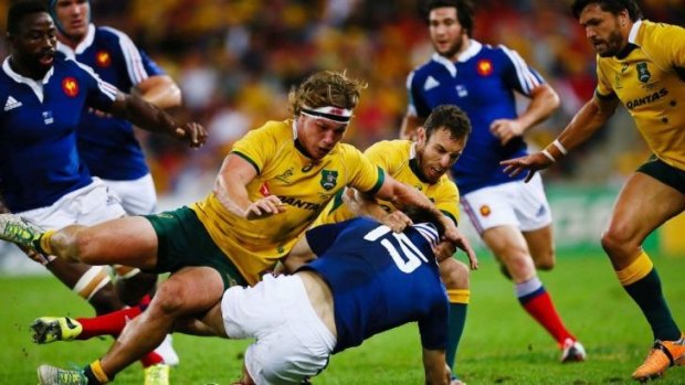 Australia's Michael Hooper and Nic White tackle France's Hugo Bonneval during Saturday's Test.