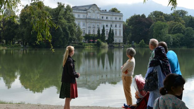 Tourists stand in front of the Leopoldskron Palace where part of the film 'Sound of Music' was shot, in Salzburg, Austria.