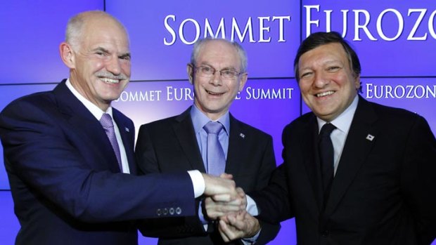 Greek Prime Minister George Papandreou (L), European Council President Herman Van Rompuy (C) and European Commission President Jose Manuel Barroso (R) shake hands at the end of an euro zone leaders crisis summit.