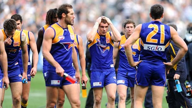 West Coast players trudge off the MCG after their loss.