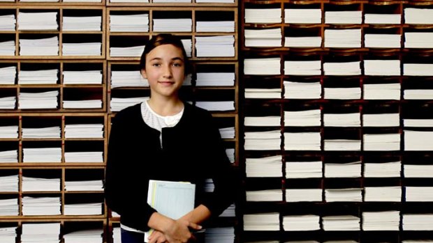 Passing her peers ... Dasha Moskalenko has been a student in the Japanese Kumon method of coaching for four years. She stands in front of the worksheets that form part of the method.