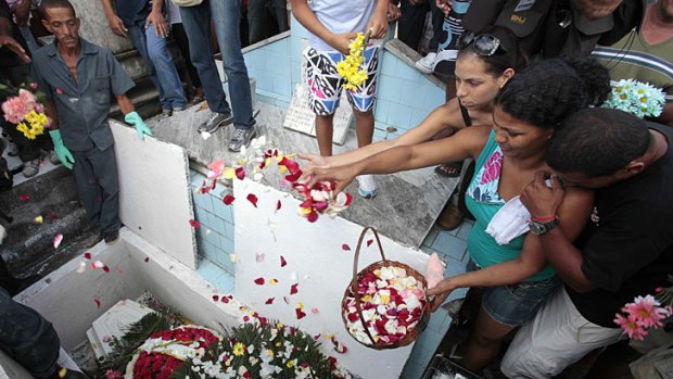 Tragic loss ... mourners sprinkle petals over the coffin of Gessica Pereira, who was 15.