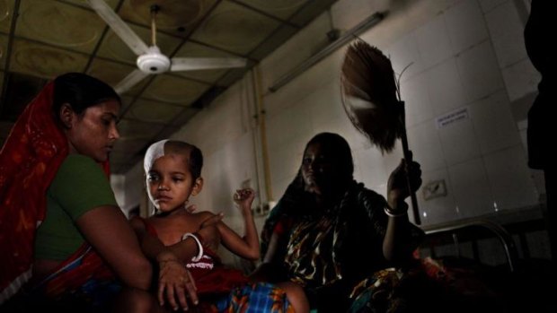 A woman fans a sick child at a hospital in Dhaka during the nationwide blackout on Saturday.