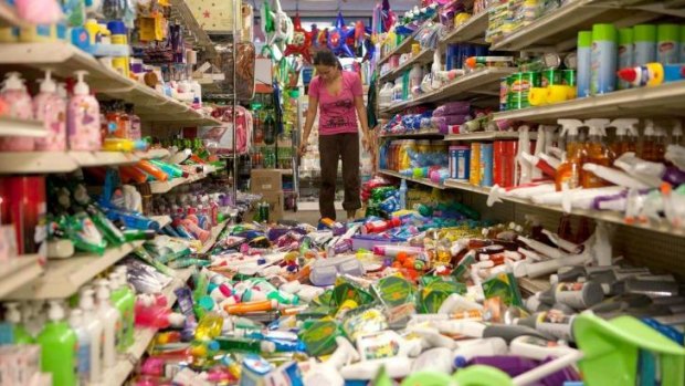 Nina Quidit cleans up the Dollar Plus and Party Supplies Store in American Canyon, California after Sunday's earthquake.
