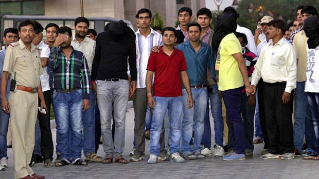 Police escort bookies and cricketers after they were produced in a court in New Delhi on Thursday.