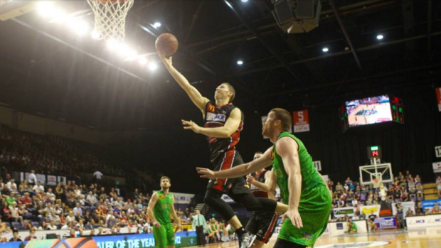 No contest: Tim Coenraad lays in an easy bucket against Townsville.