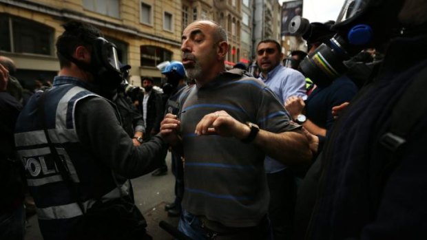 'This is where I live': Ibrahim Aktgun is grabbed by riot police during the anniversary protests in Istanbul.