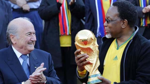 FIFA President Joseph Blatter applauds as South African Deputy President Kgalema Motlanthe holds the World Cup 2010 trophy during a ceremony at Union Building in Pretoria yesterday.