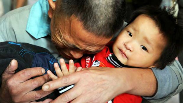 One of the lucky few: A father is reunited with his rescued son.