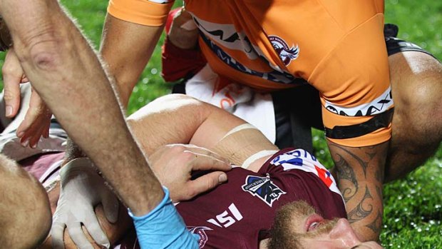 Out for six months ...  David Williams of the Sea Eagles receives attention from the trainers after breaking his neck during Friday night's game against the Melbourne Storm.