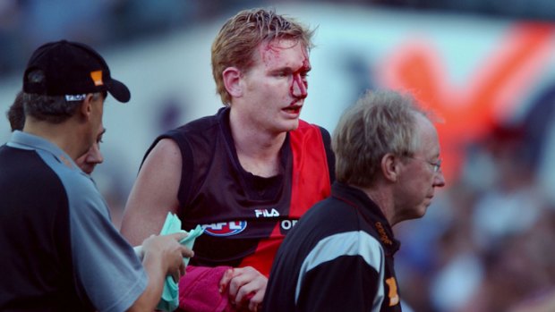 James Hird is helped from the ground after suffering head injuries likened to those from a high-speed car crash during a match against Fremantle in 2002.