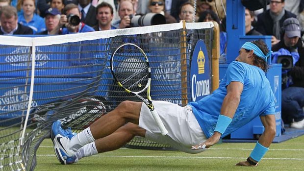 Exhausted: World No.1 Rafael Nadal slips during his 6-7 (3-7), 6-4, 6-1 loss to France's Jo-Wilfried Tsonga at Queen's in London.